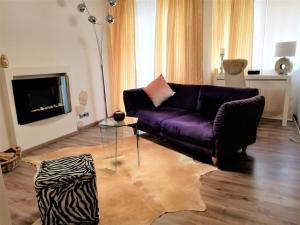 a living room with a purple couch and a fireplace at Wohnung Stuttgart Mitte in Stuttgart