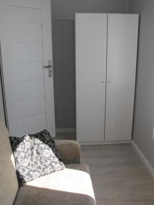 a living room with a couch and a closet at Apartament Mierzeja in Sztutowo