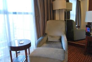 uma sala de estar com uma cadeira e uma mesa em Crowne Plaza Beijing International Airport, an IHG Hotel em Shunyi