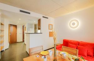 a living room with a red couch and a table at Residence Kalliste in Ajaccio
