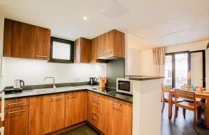 a kitchen with wooden cabinets and a table at Residence Kalliste in Ajaccio