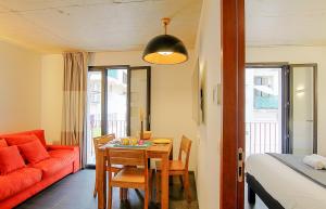 a living room with a table and a red couch at Residence Kalliste in Ajaccio