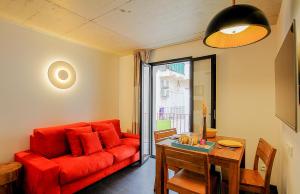 a living room with a red couch and a table at Residence Kalliste in Ajaccio