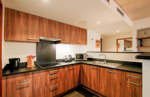 a kitchen with wooden cabinets and a sink at Residence Kalliste in Ajaccio