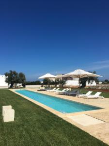 basen z leżakami i parasolami w obiekcie Masseria San Giovanni - Epoca Collection w mieście Fasano