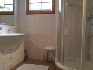 a bathroom with a shower and a sink and a stool at Schuistlhof in Sillian