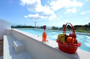 a basket of fruit sitting on a ledge next to a swimming pool at Kathara Bay Apartments in Faliraki