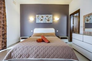 una camera da letto con un letto con due cuscini arancioni sopra di Dolphin Court a Marsalforn