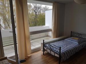- une chambre avec un lit et une grande fenêtre dans l'établissement Hannover Messe-Wohnung, à Hanovre