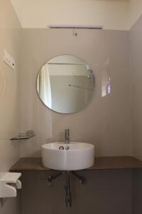 lavabo blanco en el baño con espejo en Most convenient 2 BR apartment in central Anjuna, en Anjuna