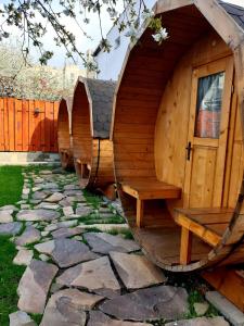 a wooden hobbit house with a bench in a yard at Zozo House in Braşov