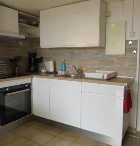 - une cuisine avec des placards blancs et un évier dans l'établissement appartement 5 personnes résidence piscine 5PB274, au Barcarès