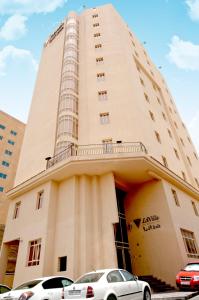 due auto parcheggiate di fronte a un edificio di La Villa Hotel a Doha