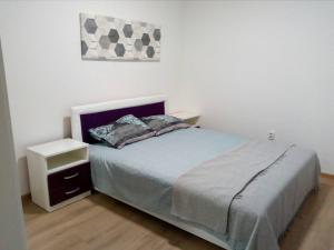 um quarto com uma cama com uma mesa de cabeceira e uma fotografia em Anni em Belgrado