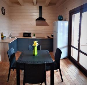 uma cozinha com uma mesa com cadeiras e um frigorífico em Lazur Hills em Sanzhiyka