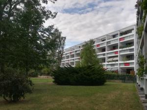 un immeuble d'appartements avec une brousse en face dans l'établissement Hannover Messe-Wohnung, à Hanovre