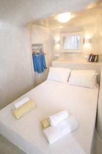 a small bedroom with two beds in a caravan at White Cave House in Oia