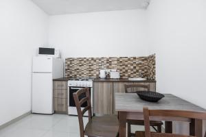 cocina con mesa y nevera blanca en Dolphin Court, en Marsalforn