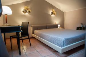 Schlafzimmer mit einem Bett, einem Tisch und einem Schreibtisch in der Unterkunft RESIDENZA D'ORIA B&B in Foggia
