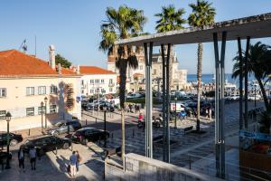 a view of a city with palm trees and buildings at Cascais Bay Hostel in Cascais
