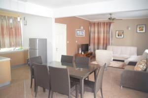 a dining room and living room with a table and chairs at Sun Villa Mont Choisy Apartments in Mont Choisy