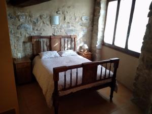 um quarto com uma cama numa parede de pedra em CASA VICENT em Valderrobres