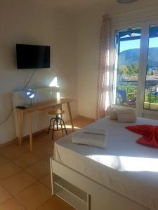 a bedroom with a bed and a desk and a window at Elaia country living in Galatas