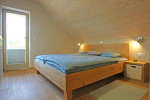 a bedroom with a bed with a wooden ceiling at Apartma - Počitniška hiša Lodi in Bohinj