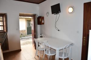 a white table and chairs in a room with a tv on the wall at Domus Avocat in Valença