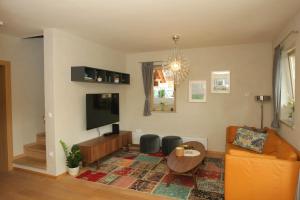 a living room with a couch and a tv at Apartma - Počitniška hiša Lodi in Bohinj