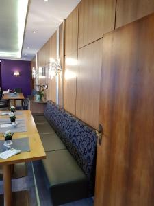 Hotel "Zum Moseltal" في ميهرينغ: مطعم بجدران خشبية وطاولات وباب