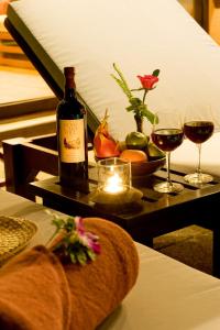 a table with a bottle of wine and two glasses at Korsiri Pool Villas in Panwa Beach +30 photos