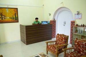 a man sitting at a counter in a room at Sunset Valley Homestay in Chikmagalūr