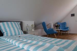 a bedroom with a bed and two blue chairs at Ankerhaus Ostholstein in Oldenburg in Holstein