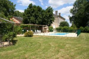 a yard with a house and a swimming pool at Le Chai Gite in Saint-Pierre-de-Côle