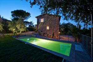 a swimming pool in the yard of a house at Podere San Quirico in Castelnuovo Berardenga
