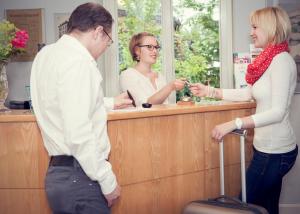 Ein Mann und eine Frau stehen an einem Tresen in der Unterkunft Hotel zum Scheppen Eck in Wiesbaden