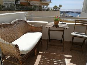 a wicker chair and a table on a balcony at Cerquita de la playa in Era de Soler