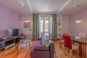 a living room with a purple couch and a table at Pula Citybreak in Pula