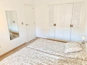 una camera bianca con letto e specchio di Apartamento Fuengirola R09 Edificio Ronda IV a Fuengirola