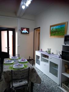 ein Wohnzimmer mit einem Tisch und einem TV an der Wand in der Unterkunft La casa di nuvola in Massino Visconti