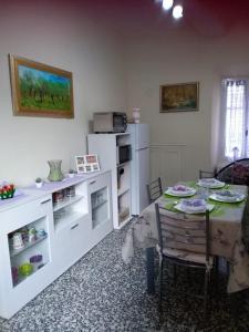 a living room with a table and a white refrigerator at La casa di nuvola in Massino Visconti