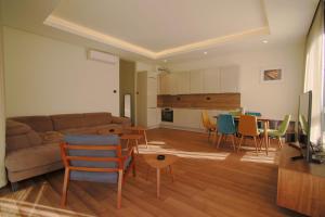 un soggiorno con divano, tavolo e sedie di Luxury Home in Tivat Centre w/ Parking - 2Br Near Porto Montenegro a Tivat