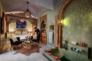 a man in a bedroom with a bed and a tub at Emma's Riad in Marrakesh