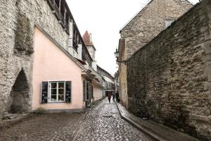 a person walking down an alley between two buildings at AirHome - Old Dominican Monastery in Tallinn