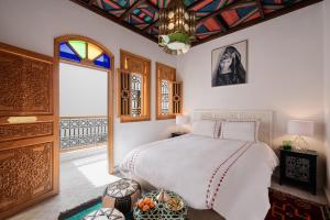 a bedroom with a bed and a window and a chandelier at Emma's Riad in Marrakech