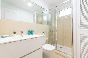 een witte badkamer met toilet en douche bij Living Las Canteras Homes - BEACH HOME in Las Palmas de Gran Canaria +28 foto's