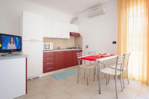 a kitchen with a red table and chairs and a tv at Villa Maria in Caorle