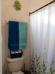 a bathroom with a toilet with a blue towel at Casa Marino Rivera Maya in Puerto Aventuras