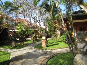 a path leading to a house with a statue at Laghawa Beach Hotel in Sanur
